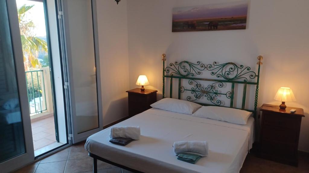圣凯撒利亚温泉Residence Porto Miggiano的一间带白色床的卧室和一个阳台