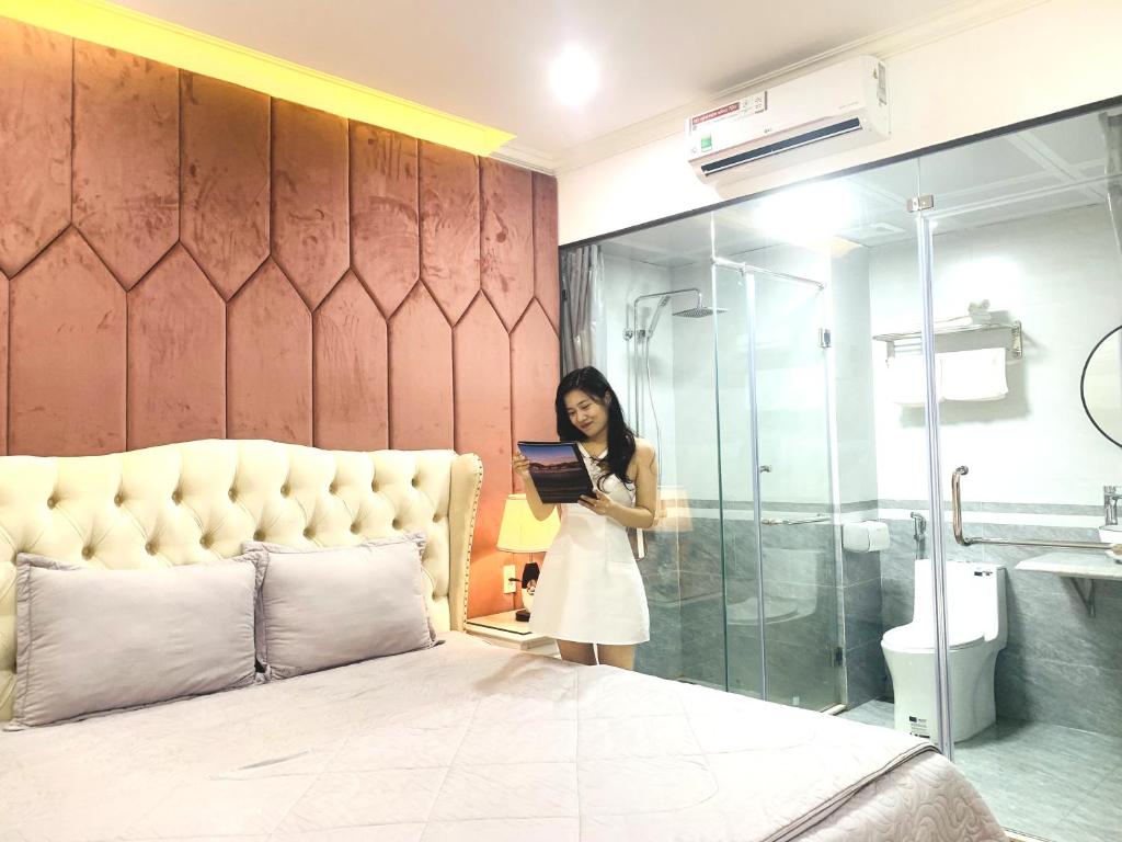下龙湾Ánh Dương Villa Homestay Hạ Long 7 Phòng ngủ cách Bãi biển 200m的站在浴室床边的女人