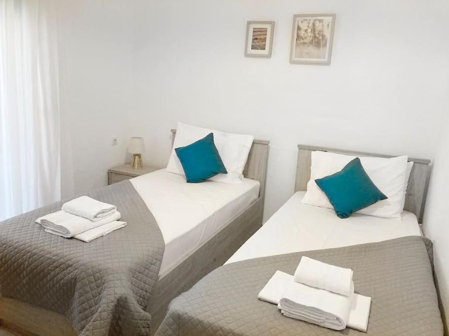 阿莫利亚尼岛Mokamvilia House的配有两张床铺的蓝色和白色枕头
