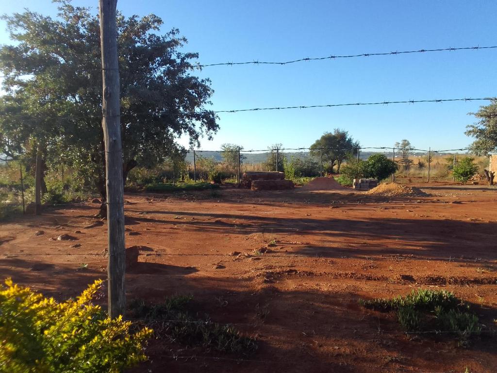 RosslynKGOLA SAFARIS的田野上一条带电话杆的土路