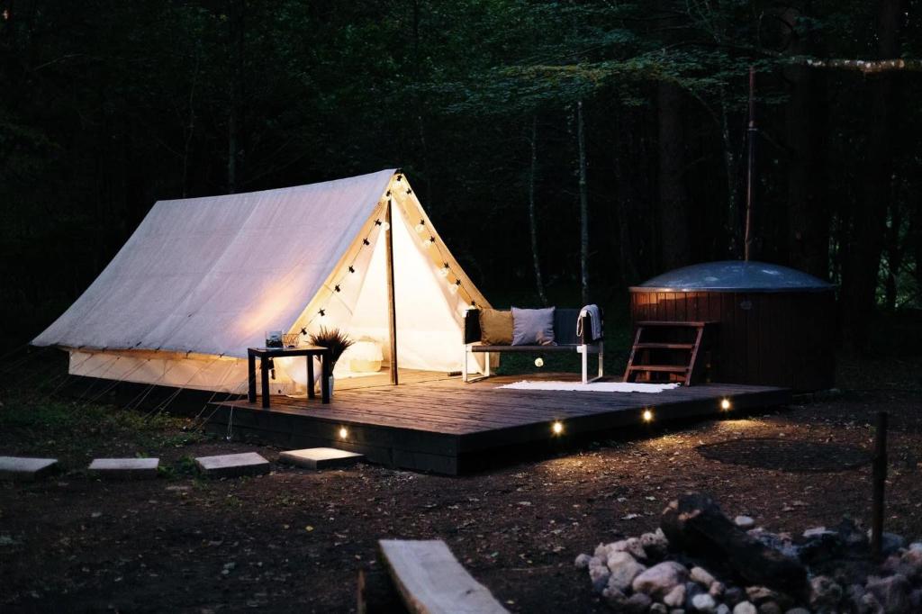 利加特内Glempings Jaunsaimnieki的帐篷设有带桌椅的木制甲板