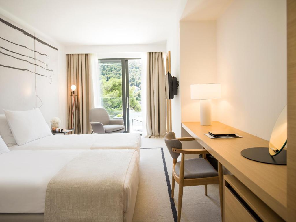 杜布罗夫尼克考帕斯酒店的配有一张床和一张书桌的酒店客房