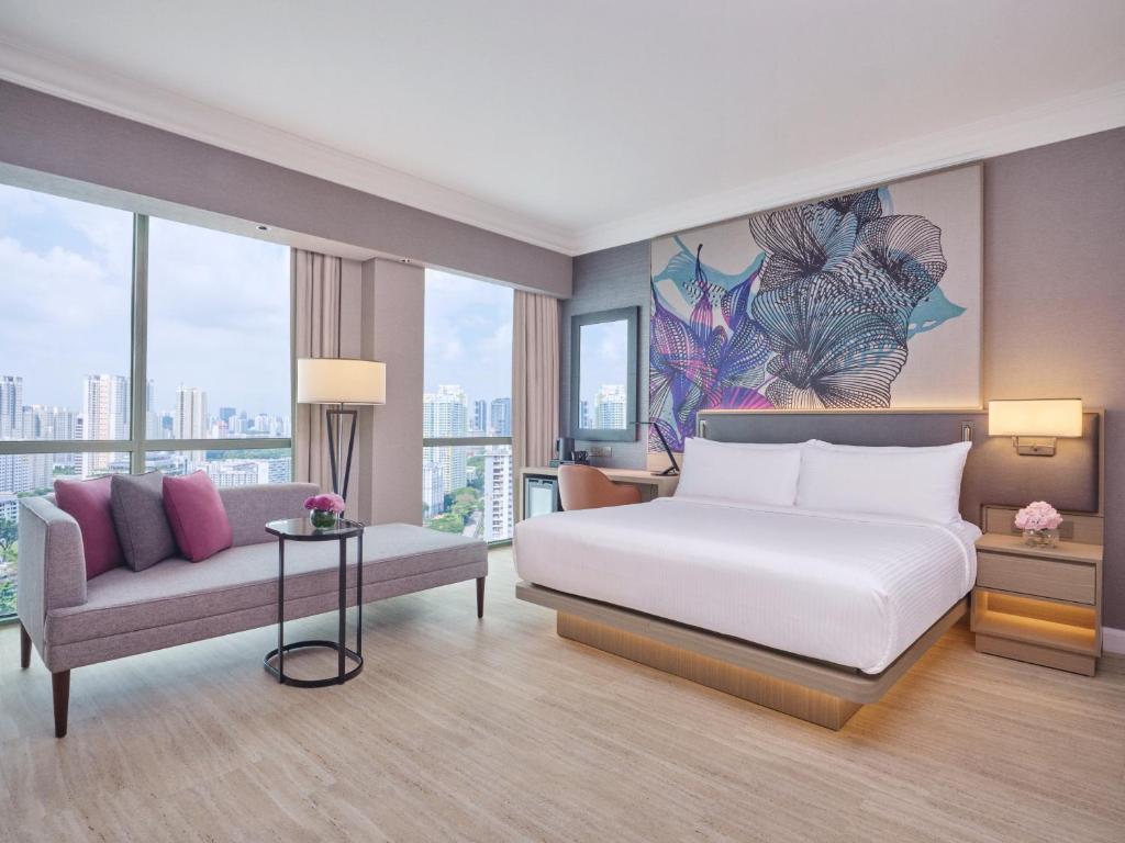 新加坡Grand Copthorne Waterfront的一间卧室配有一张床、一张沙发和窗户。