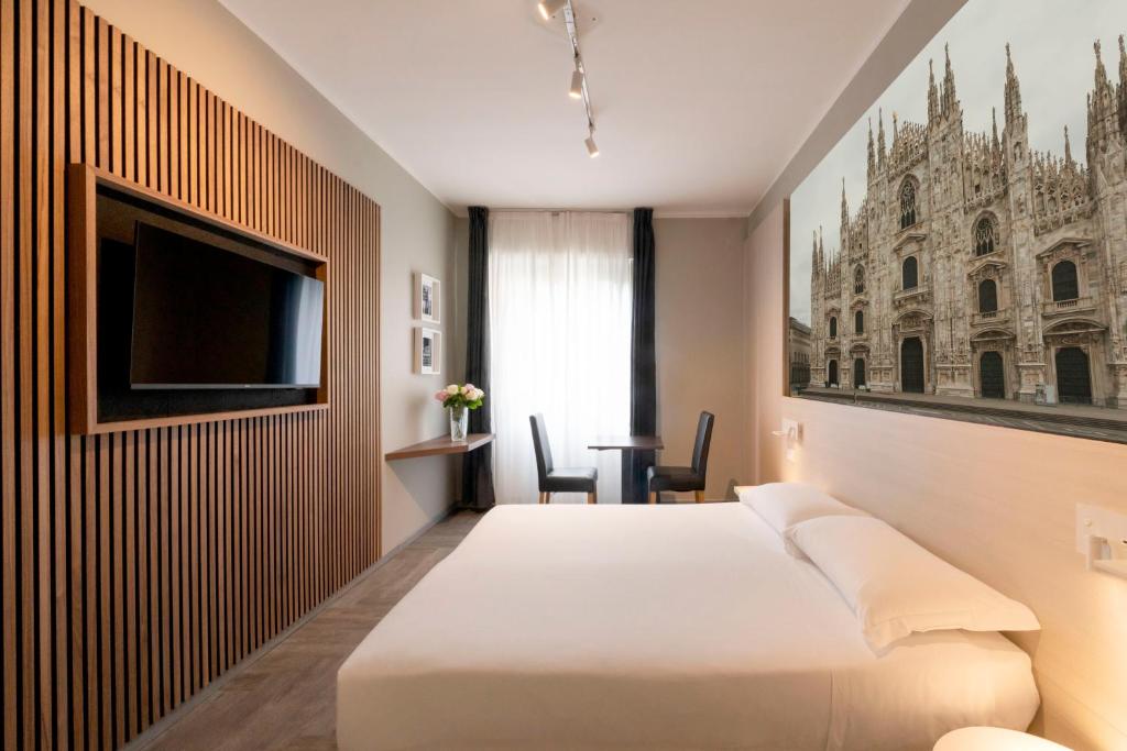 米兰Kleos Hotel Milano的配有一张床和一台平面电视的酒店客房
