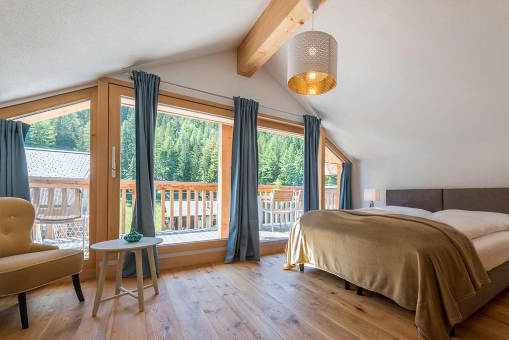 萨斯格伦德Montela Hotel & Resort - Suiten的一间卧室设有一张床和一个大窗户