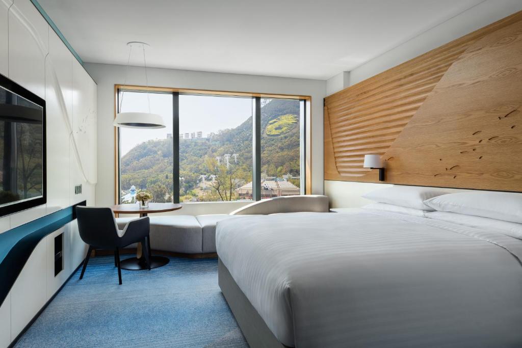 香港香港海洋公园万豪酒店的一间卧室配有一张床、一张书桌和一个窗户。