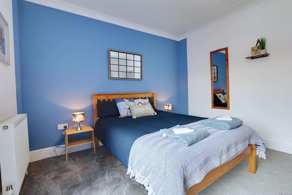克利索普斯Cosy home by the sea的蓝色的卧室,配有一张蓝色墙壁的床
