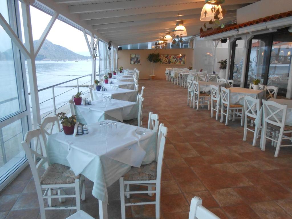 托隆Hotel Assini Beach Tolo的餐厅里一排桌椅