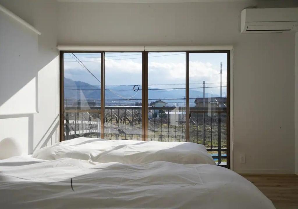 甲州Kajitsuno mieru yado - Vacation STAY 06979v的卧室设有白色的床和大窗户