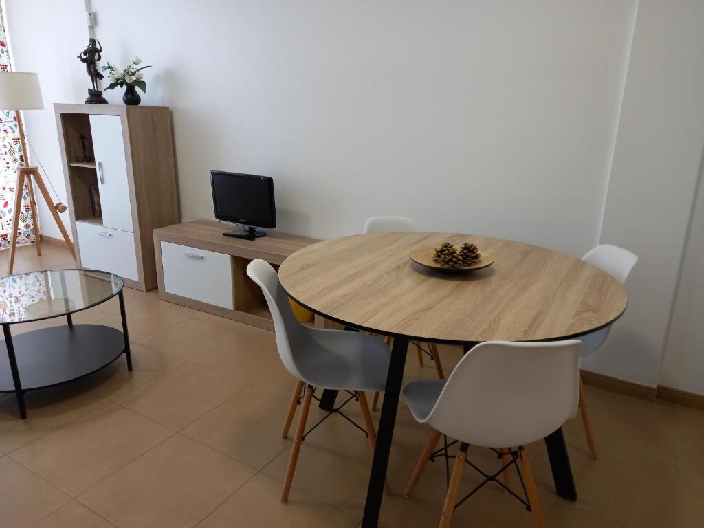 阿德拉Apartamento El Ingenio的一间带木桌和椅子的用餐室
