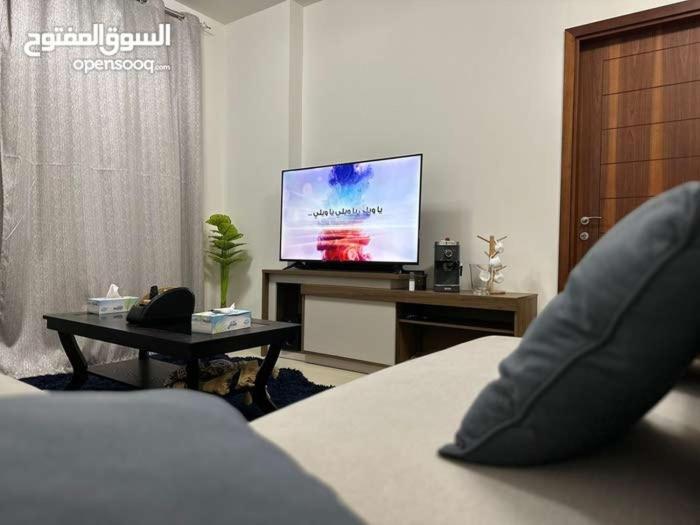 马斯喀特One Bed Room Apartment Muscat Hills的一间带床和电视的客厅