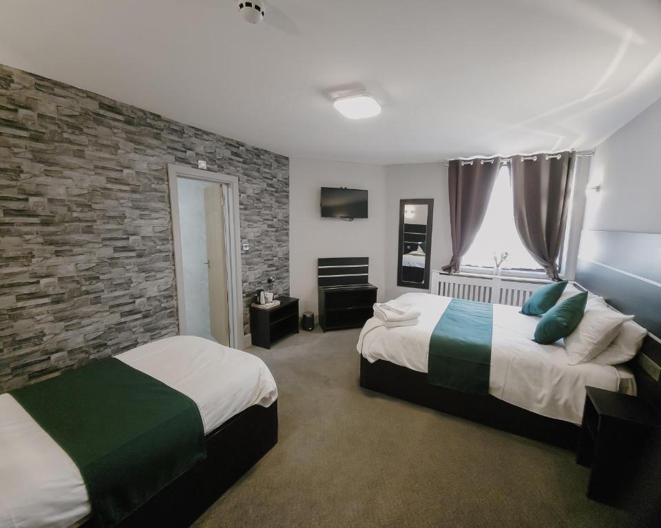 埃布韦尔Level Inn的一间卧室设有两张床和砖墙