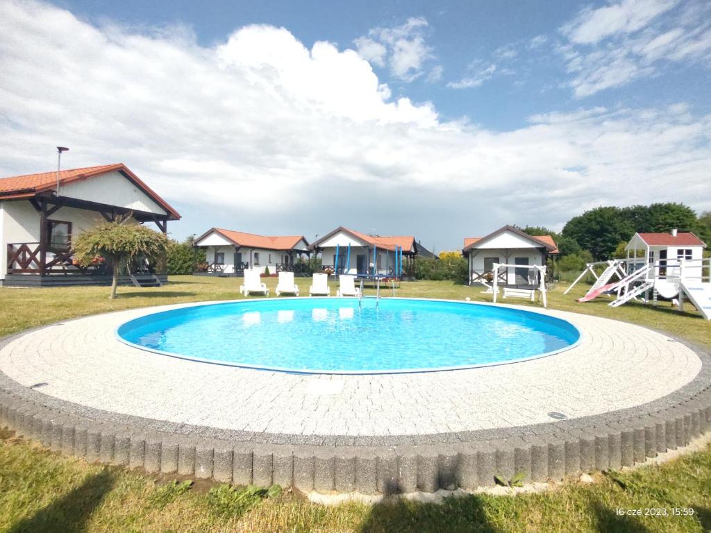达尔沃沃Polne Domki的一座带房屋的庭院内的大型游泳池