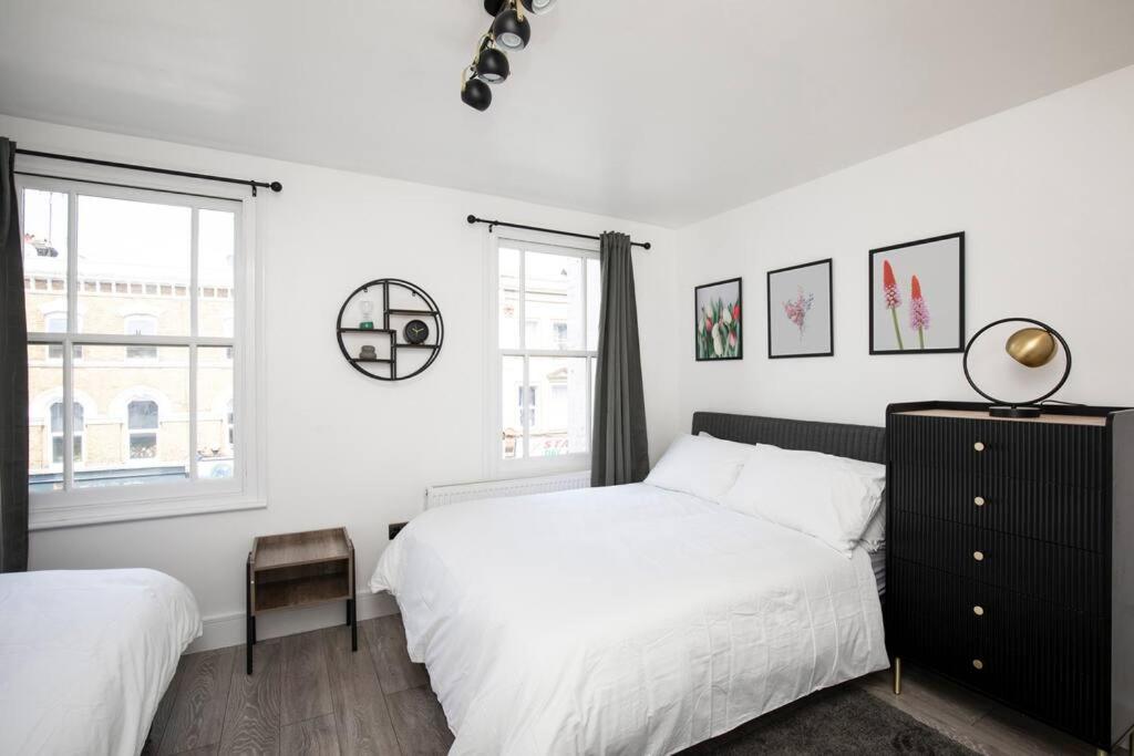 伦敦Spacious Serenity in the Heart of Central London的一间白色卧室,配有两张床和窗户