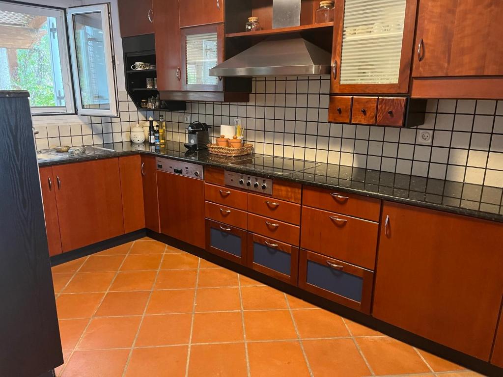 斯派赛斯Villa House 200 with sea view的一间铺有橙色地板并配有木制橱柜的厨房