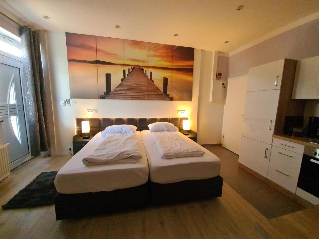 Hüllhorstferienwohnung-32609 W1的一间卧室设有两张床,墙上挂着一幅画