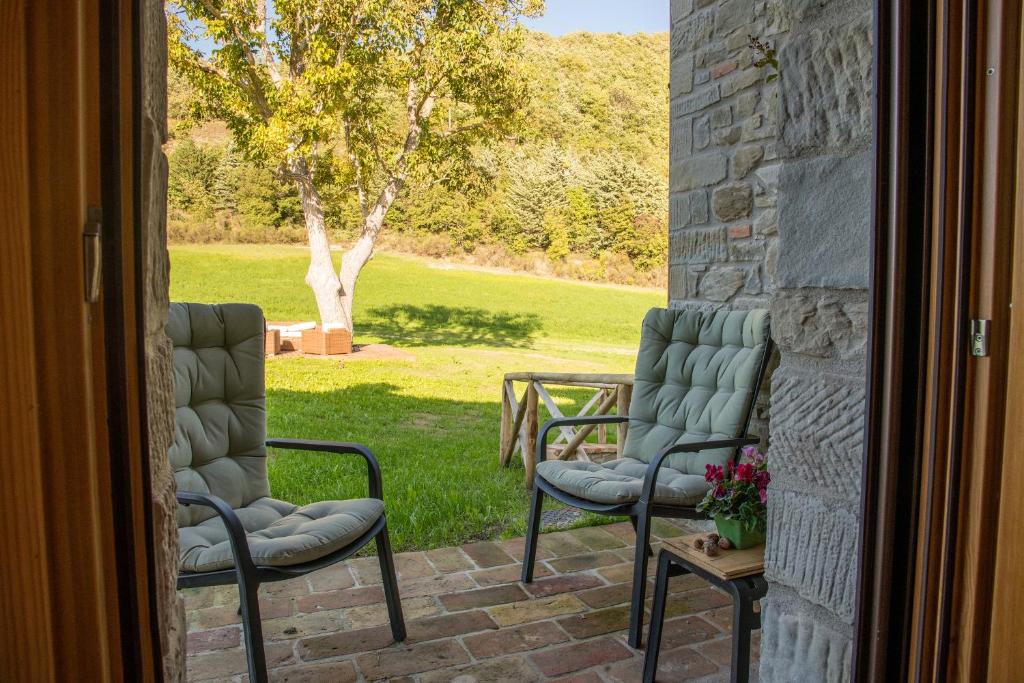 乌尔比诺Aura Relais的两把椅子坐在门外的庭院