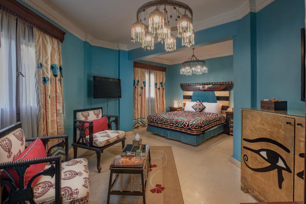 开罗Le Riad Hotel de Charme的卧室拥有蓝色的墙壁,配有一张床和一张沙发