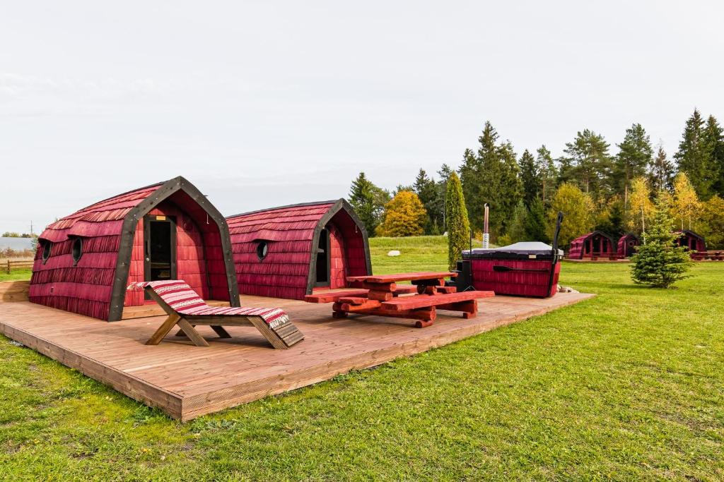 Saare Paadiküla的一个带野餐桌和长凳的红色谷仓