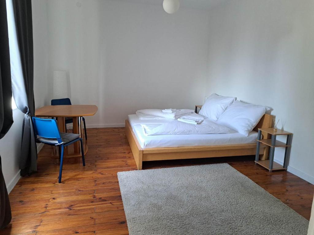 陶尔曹尔Tarcal Apartman的卧室配有1张床、1张桌子和1把椅子