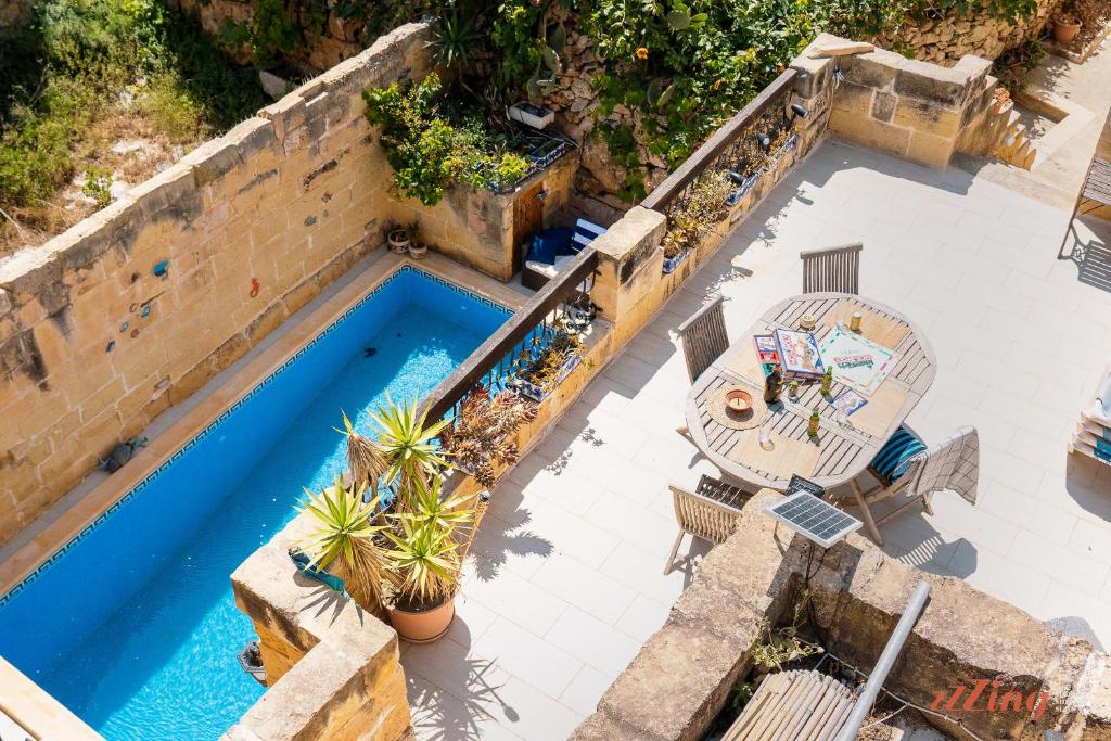 MunxarMatli Farmhouse, your stunning Gozo getaway.的享有带桌椅的游泳池的顶部景致