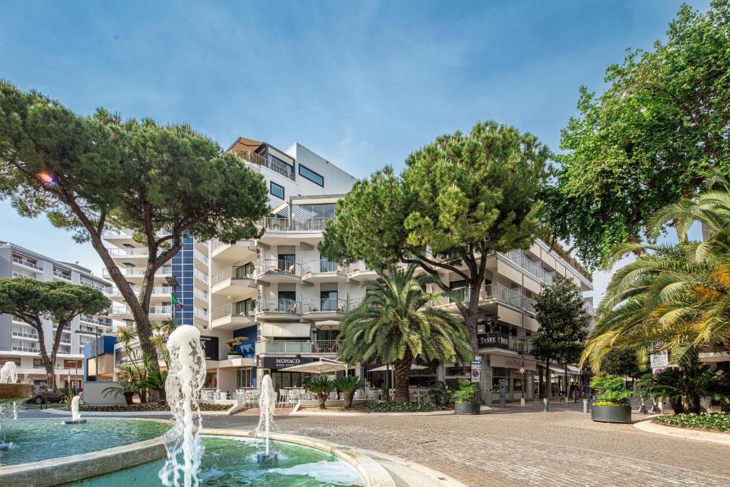 利尼亚诺萨比亚多罗Hotel Monaco的一座树木繁茂的建筑前的喷泉