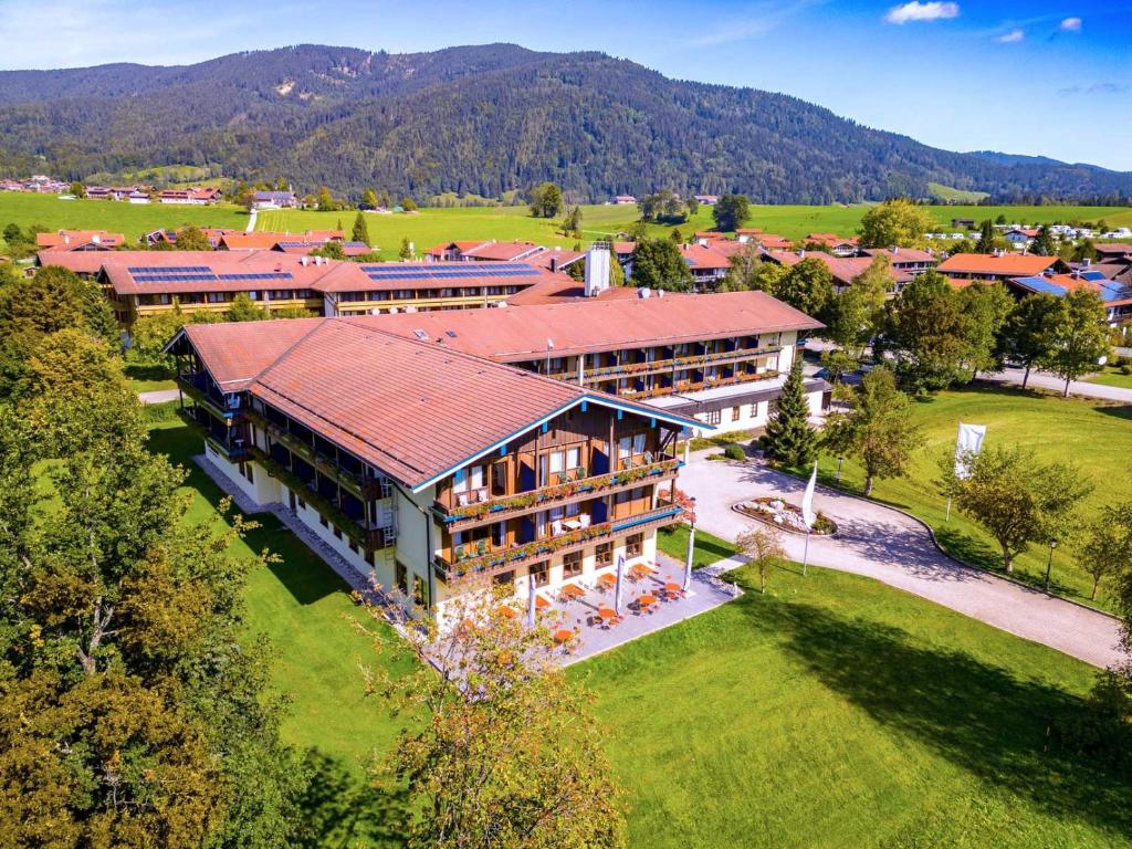 因泽尔Das Wiesgauer - Alpenhotel Inzell的享有大建筑的空中景色,背景是高山