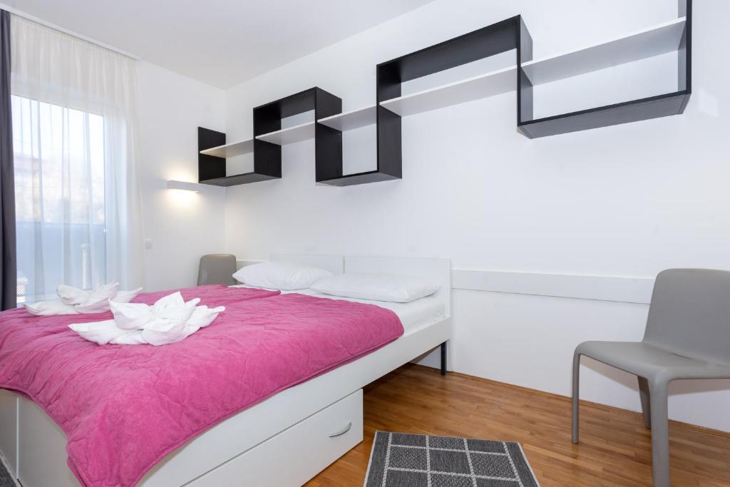 斯普利特Rooms Kampus的一间卧室配有一张带粉色毯子的床