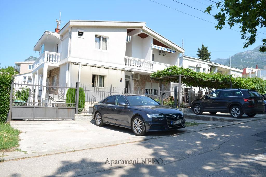 苏托莫雷Apartmani "Nebo"的两辆汽车停在房子前面