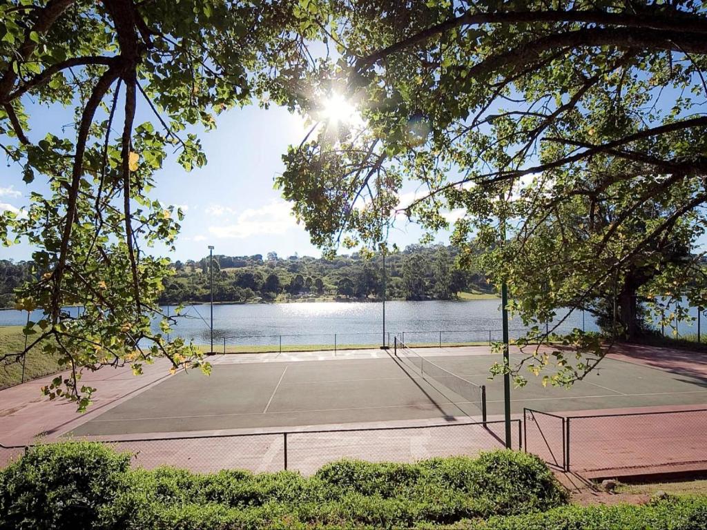 白河Blue Zone Leisure at Pine Lake Inn Resort的水边的网球场