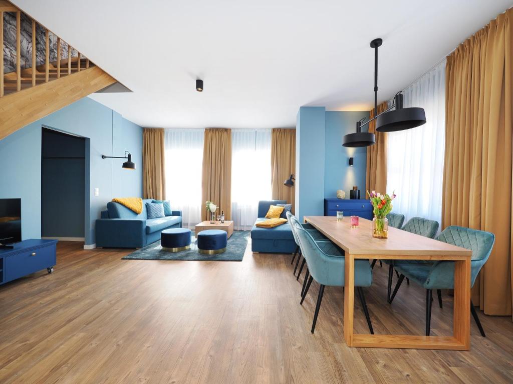 黑灵斯多夫Seebrücke Heringsdorf - Appartement mit 2 Schlafzimmern und Terrasse S17的客厅配有桌子和蓝色椅子