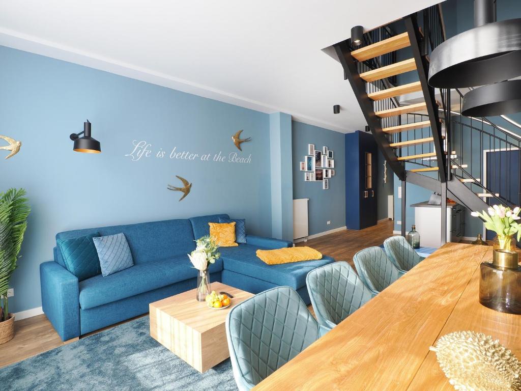 黑灵斯多夫Seebrücke Heringsdorf - Appartement mit 2 Schlafzimmern S20的客厅配有蓝色的沙发和木桌