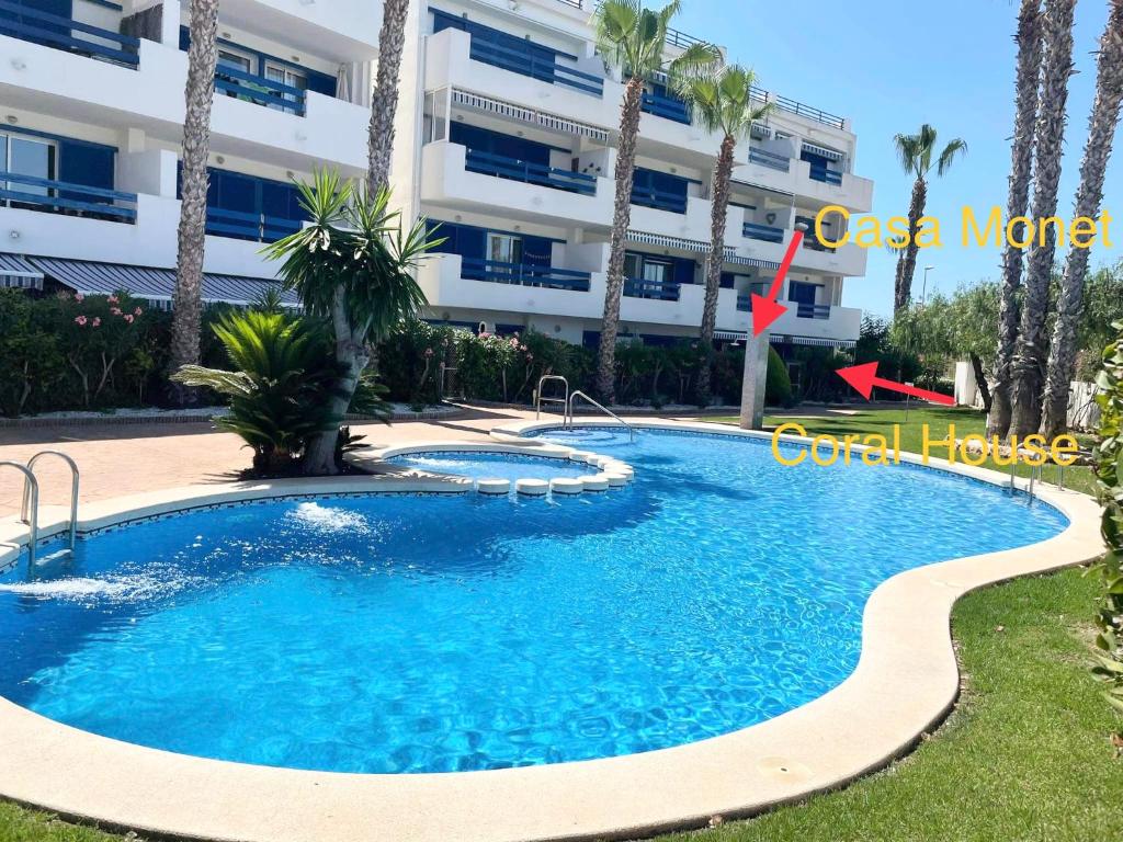 弗拉门卡海滩Casa Monet - La Calma - 4 pools- Big terrace - Orihuela Costa的大楼前的游泳池