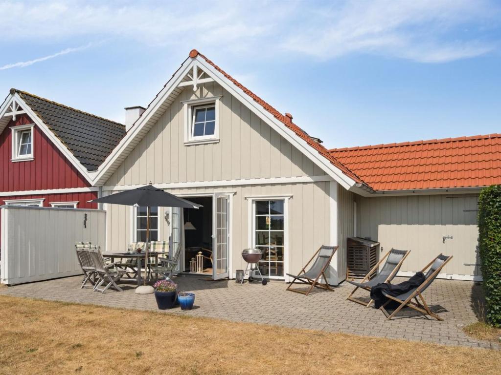 布罗Holiday Home Daniela - 300m from the sea in Funen by Interhome的房屋设有带椅子和遮阳伞的庭院