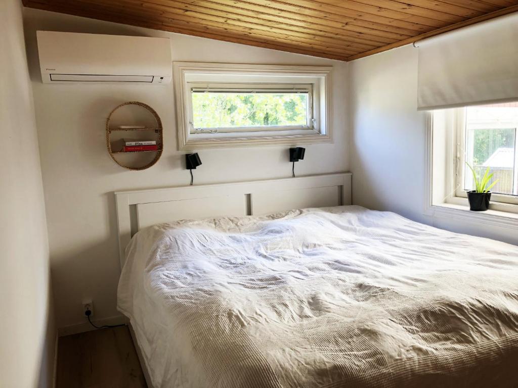 永比Nice holiday home in Tallbacken by Bolmen, Ljungby的一个小房间,设有一张白色的床,配有窗户
