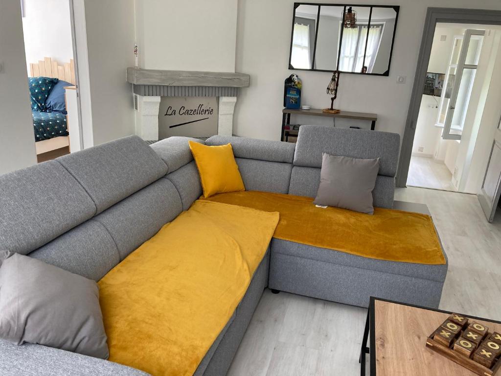 FeingsGITE DE LA CAZELLERIE的客厅里带黄色靠垫的灰色沙发