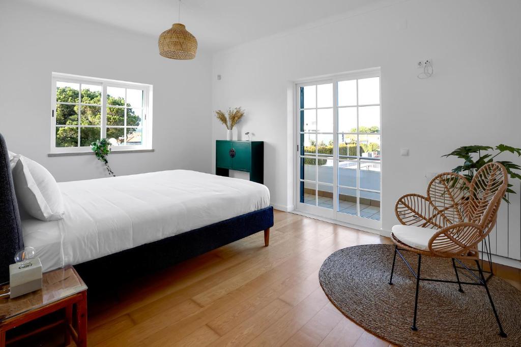 塞辛布拉Beautiful Villa in Sunny Lagoa的一间卧室配有一张床、两把椅子和一个窗户