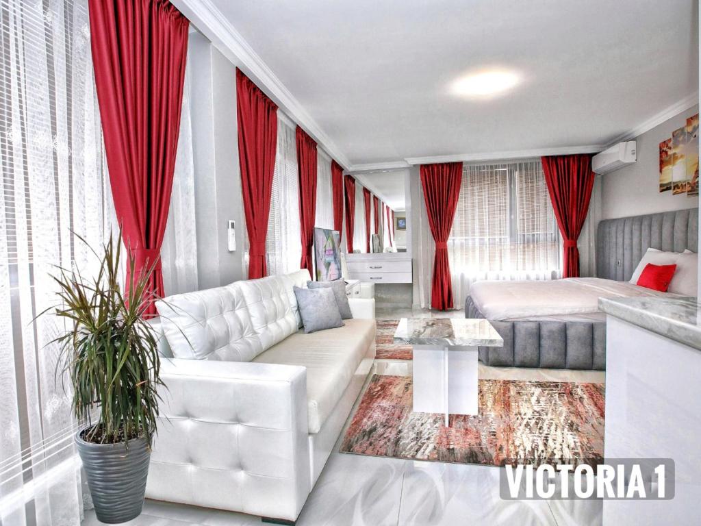 桑丹斯基Парк Апарт-Хотел Виктория 1的客厅配有白色沙发和红色窗帘