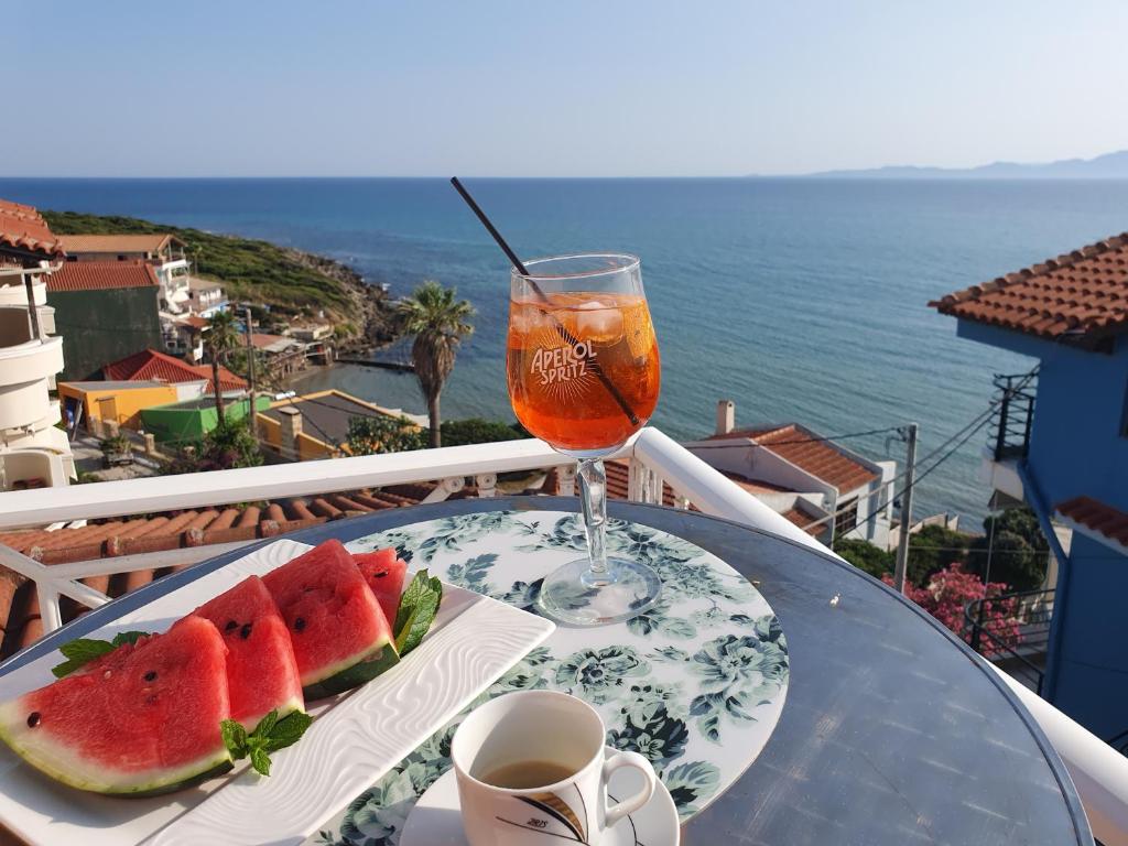 阿尔库季岛Brati II Beach Hotel的一张桌子,上面放着一盘西瓜和一杯饮料