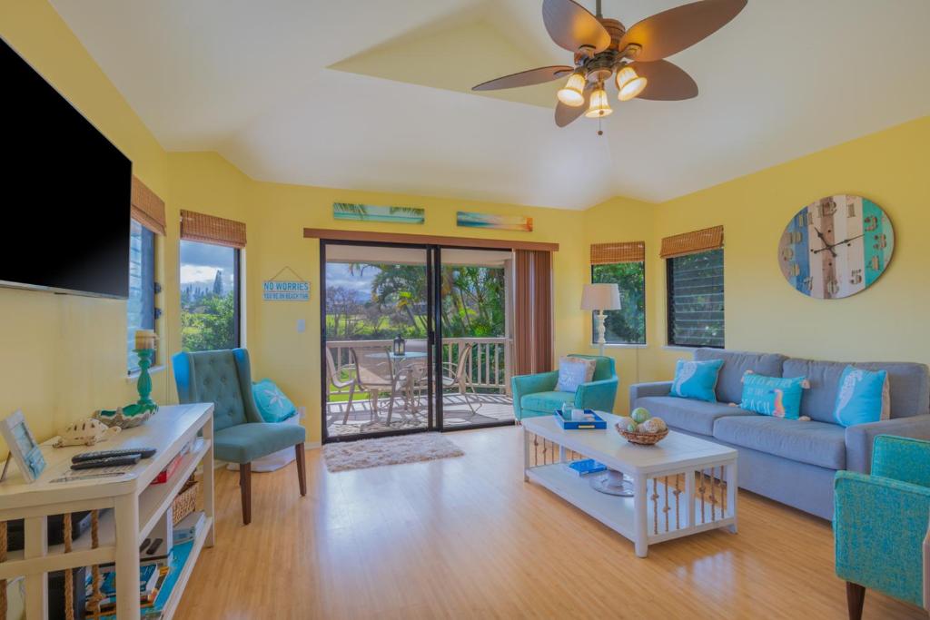 普林斯维尔Hanalei Bay Villa Cottage 2Br 2Ba with Mountain Views HBV24的客厅配有蓝色的家具和吊扇