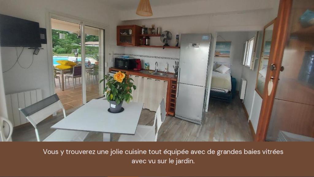 梅里尼亚克Mignon petit appartement indépendant的厨房配有一张桌子,上面放着花瓶