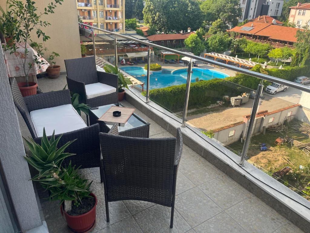 希萨里亚Апартамент Панорама的一个带桌椅的阳台和一个游泳池