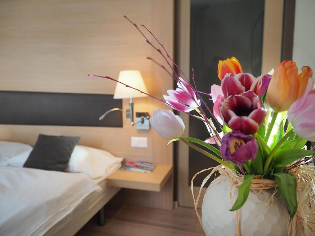 Ponte BrollaRistorante Charme Hotel Tre Terre的卧室里满是五颜六色花的花瓶