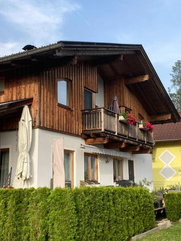 格赖芬堡Fewo Waldheim的带阳台的房子和阳台上的女人