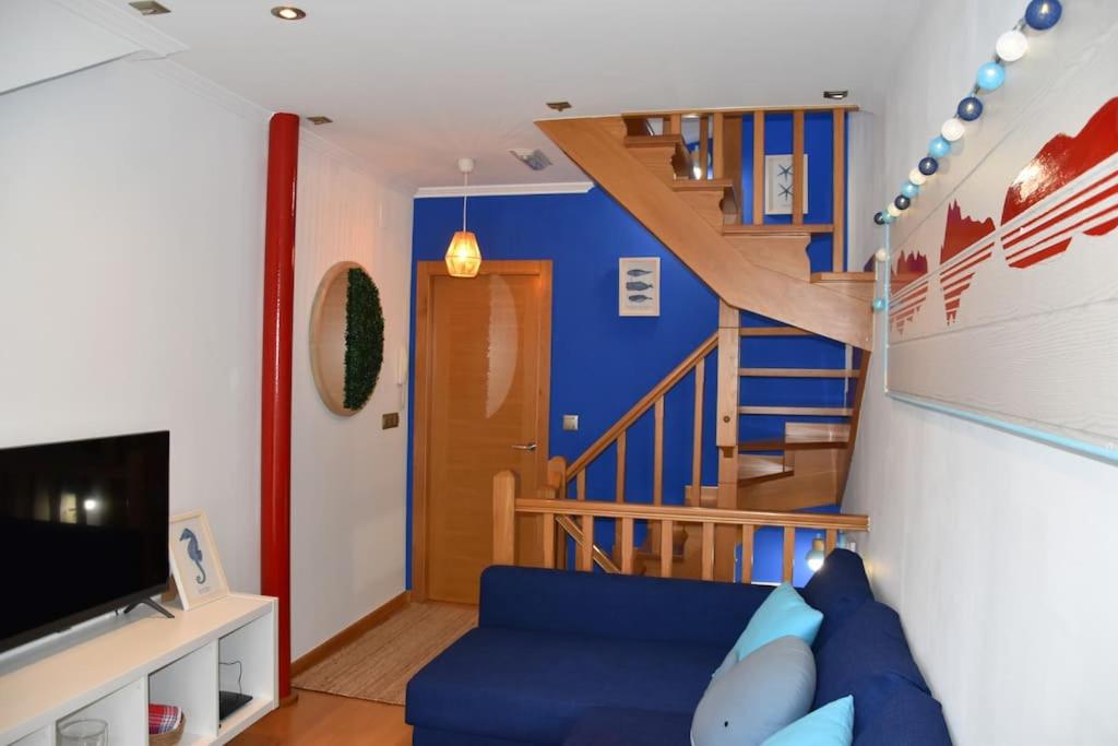 坎加斯德穆拉索Casa Punta Balea, en el centro的客厅设有蓝色的沙发和楼梯。