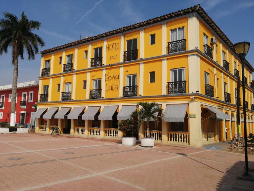 特拉科塔尔潘Hotel Posada Doña Lala的一座棕榈树的黄色建筑