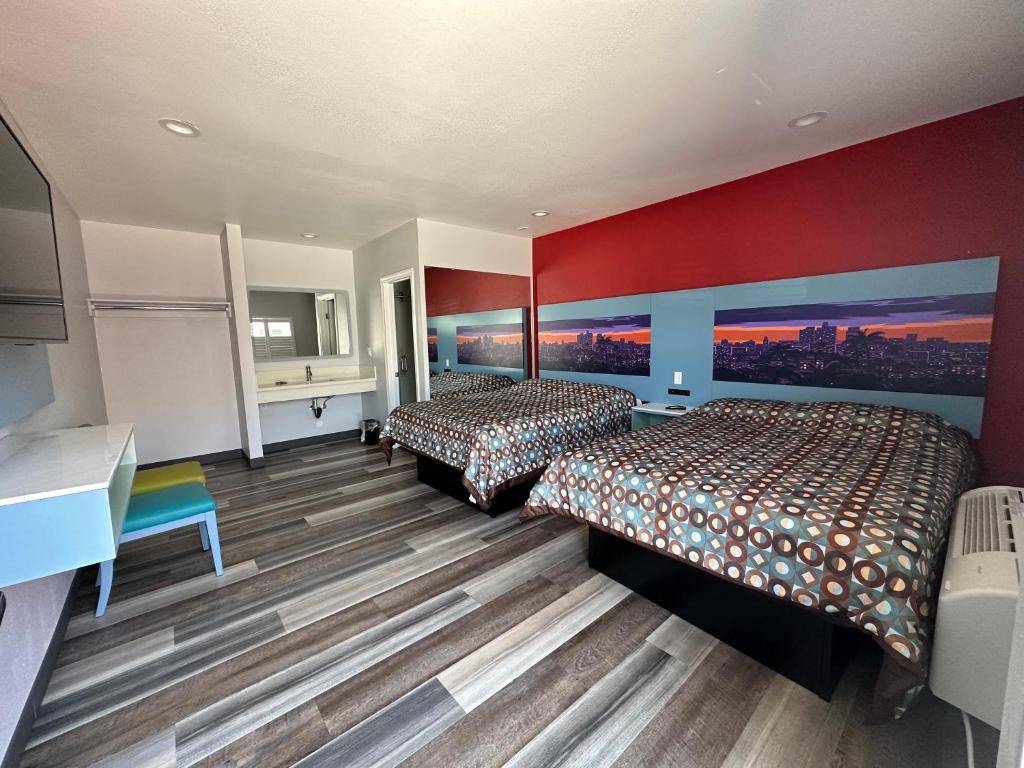 森瓦利La Casa Motel, Los Angeles - Burbank Airport的红色墙壁的酒店客房内的两张床