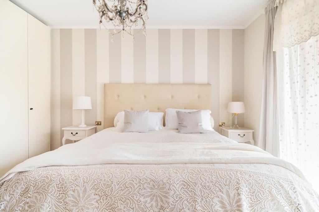 路伊斯亚戈菲奥伦扎公寓的卧室配有一张白色大床和条纹墙