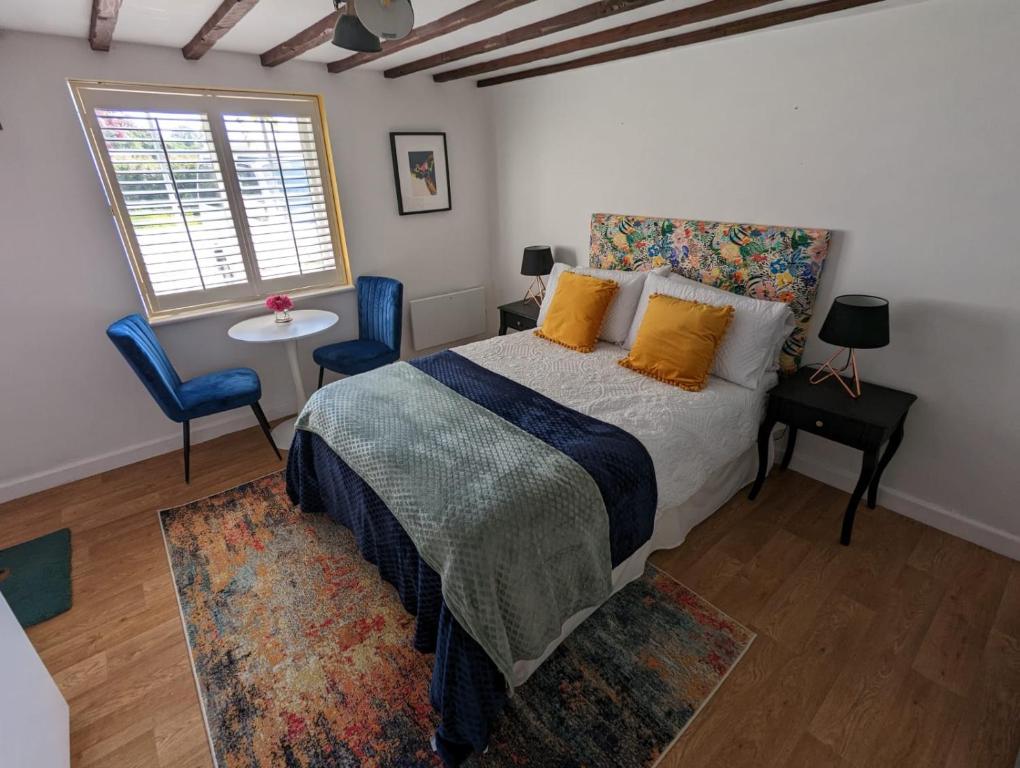 科尔切斯特Sunrise Studio的一间卧室配有一张床、两把椅子和一个窗户