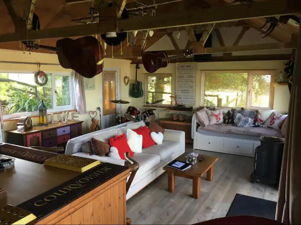 LlanasaAngies Den - quirky cabin with hot tub & views的客厅配有沙发和桌子